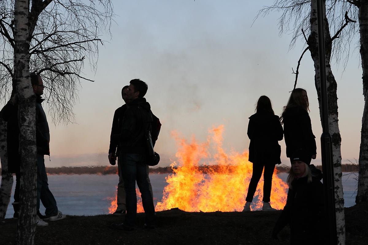 Personer som står vid en eld utomhus