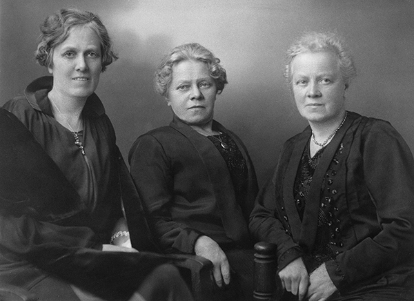 Tre äldre kvinnor porträtterade.