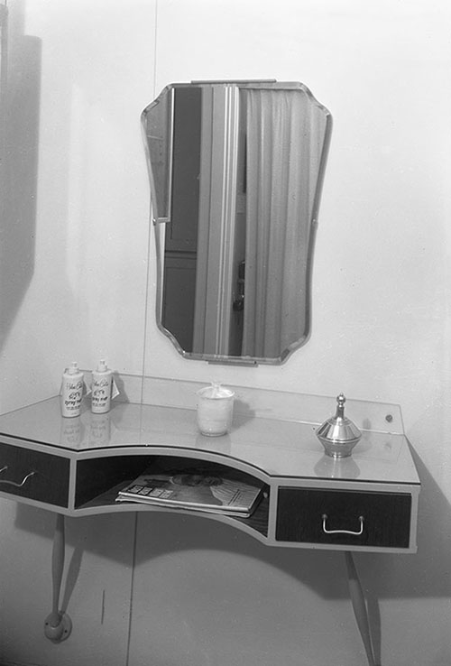 Spegel och väggfast bord i frisersalong.