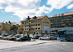 Vy över kvarter med bilparkering i förgrunden.