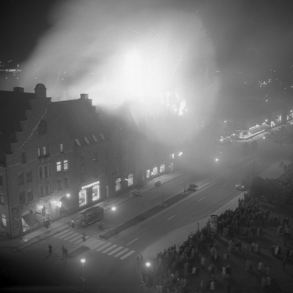 Foto uppifrån av hus som brinner i staden.