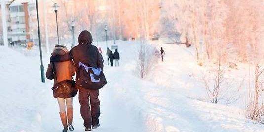 Bild på personer ute och går i ett snörikt Luleå