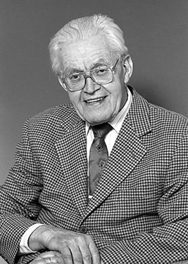 Porträtt av Helmer Widlund, äldre herre med grått hår. glasögon och smårutig kavaj.