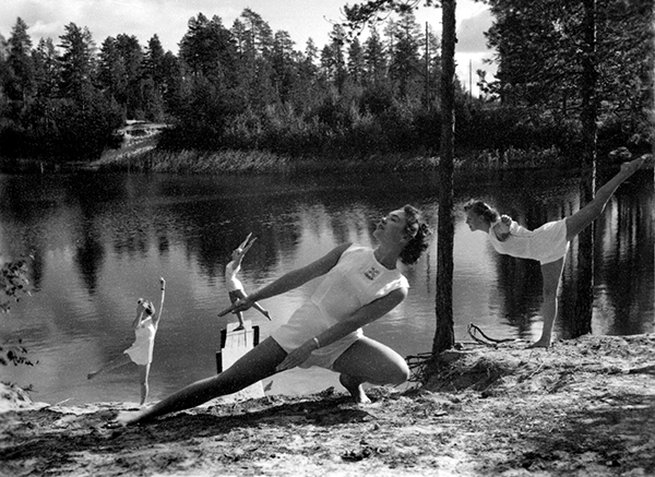 Kvinnliga gymnaster vid skogstjärn.
