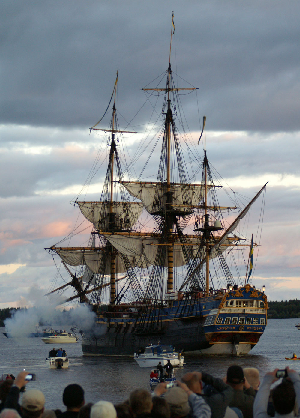 Stort segelfartyg av 1600-talsmodell. Rök kommer ut från kanonport.