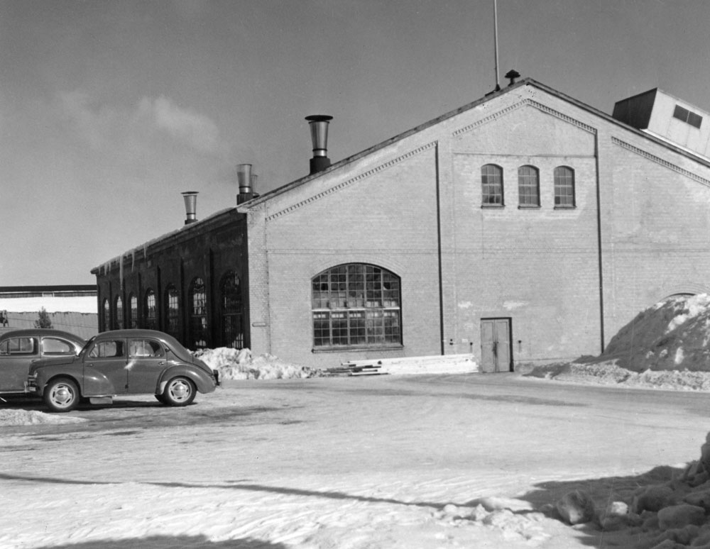 Fabriksbyggnad av tegel med stora fönster.