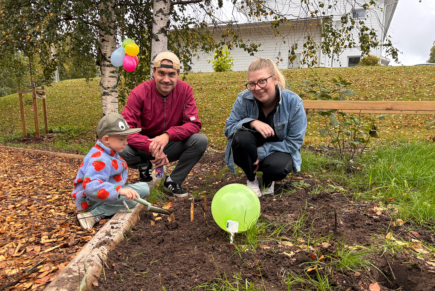 Dagens höjdpunkt var att få plantera lökar som till våren ska bli vackra pingstliljor och tulpaner. Albert Nyström 5 år, pappa Jesper Nyström och mamma Sandra Nyström som bor två hus från lekplatsen i Bensbyn var jättenöjda och glada över att ha fått en lekplats i bostadsområdet.