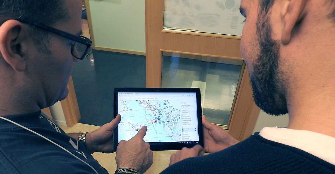 GIS-ingenjörer visar på kartapplikation på bärbar dator