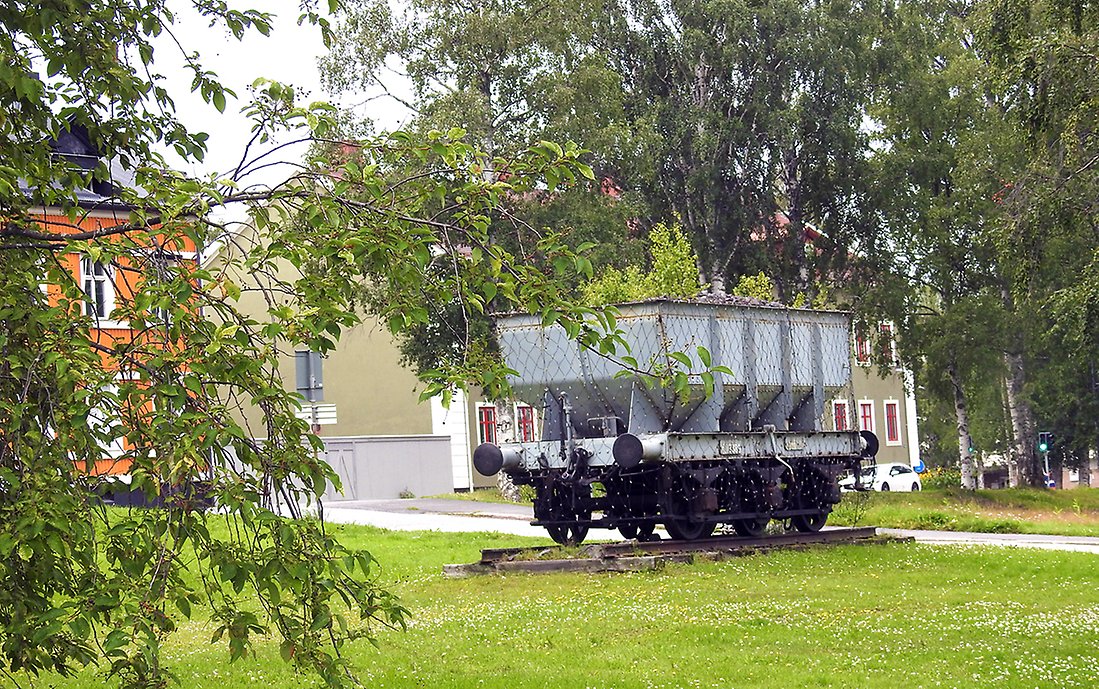Järnvägsvagnen som står i parken ovanför järnvägsstationen. Den är täckt av ett nät som lyser på vintern. 