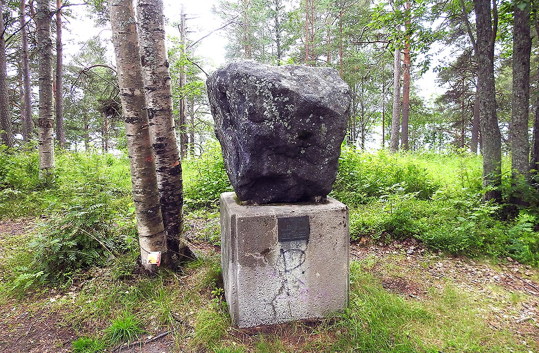 En tre ton tung järnmalmssten på en sockel med inskription på står uppe på en kulle i parken